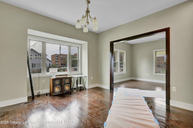 1127 W Saginaw St, Lansing, MI 48915 - dining room with dark wood-style flooring, baseboards, visible vents, and a notable chandelier