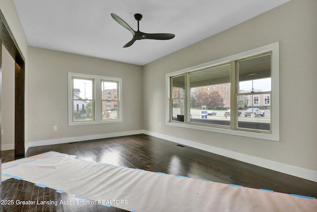 1127 W Saginaw St, Lansing, MI 48915 - unfurnished bedroom with baseboards, ceiling fan, and dark wood-style floors