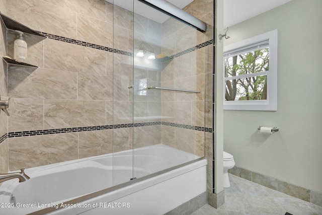 1127 W Saginaw St, Lansing, MI 48915 - bathroom featuring bath / shower combo with glass door, baseboards, and toilet