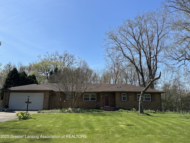 ranch-style house featuring an attached garage, concrete driveway, a front yard, and brick siding