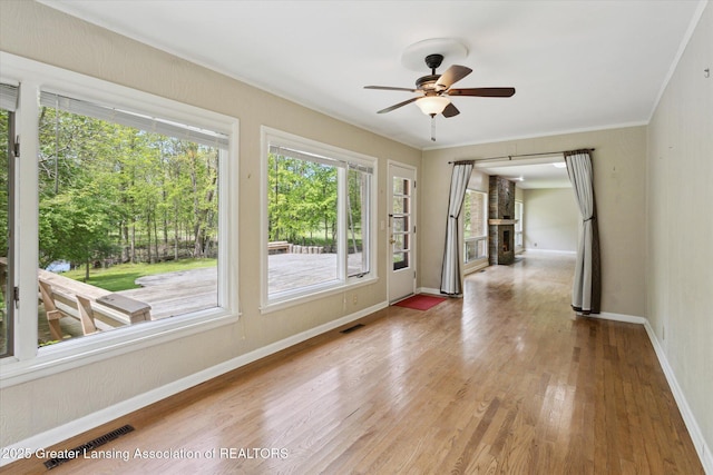 4793 Ottawa Dr, Okemos, MI 48864 - unfurnished room with wood finished floors, a ceiling fan, baseboards, and a fireplace