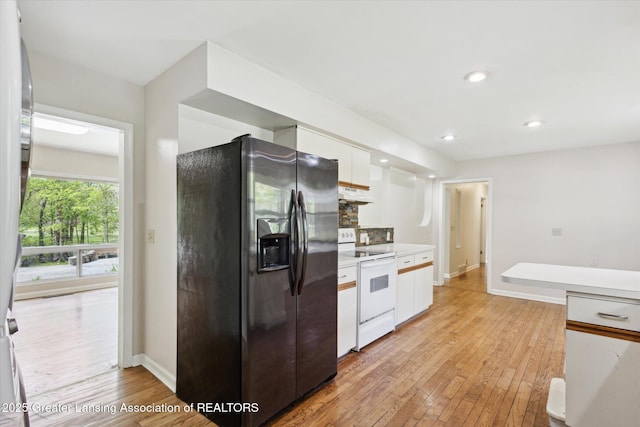 4793 Ottawa Dr, Okemos, MI 48864 - kitchen with fridge with ice dispenser, white electric range oven, under cabinet range hood, white cabinets, and light wood finished floors