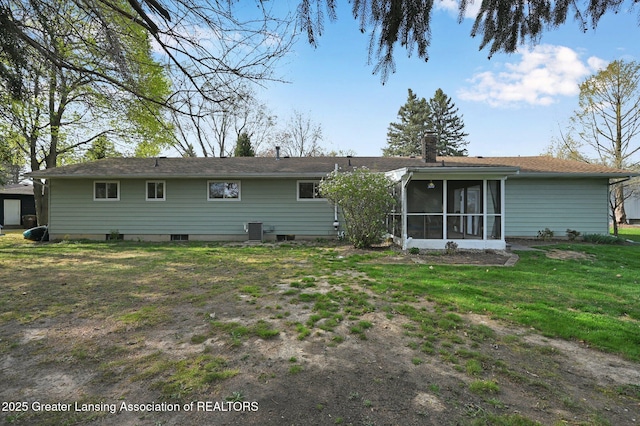 back of property featuring a sunroom, a yard, and a chimney