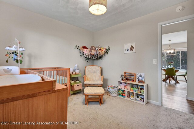 bedroom with an inviting chandelier, baseboards, and carpet flooring