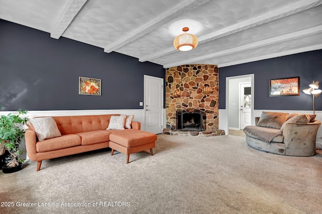 carpeted living room featuring a fireplace and beamed ceiling