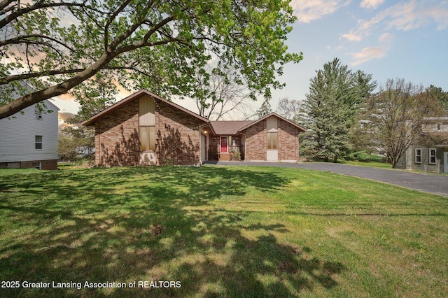 single story home with brick siding and a front lawn