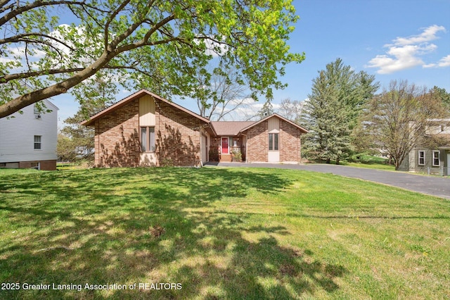 view of front facade with brick siding and a front yard
