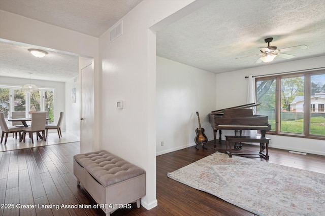 sitting room featuring visible vents, a ceiling fan, a textured ceiling, and hardwood / wood-style floors