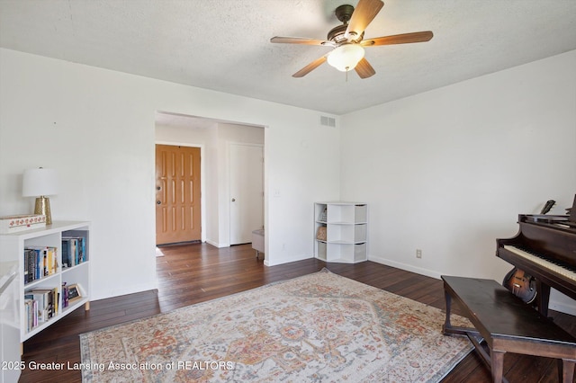 sitting room with a textured ceiling, ceiling fan, visible vents, and wood finished floors