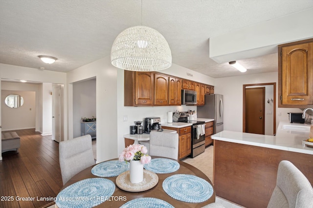 dining area with light wood-type flooring and a textured ceiling