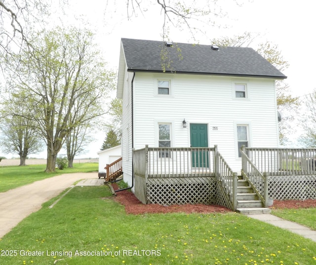 255 S Main St, Woodland, MI 48897 - rear view of property featuring a lawn, a deck, and roof with shingles