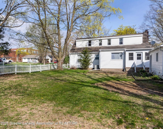 rear view of house featuring a fenced backyard, central air condition unit, a chimney, and entry steps
