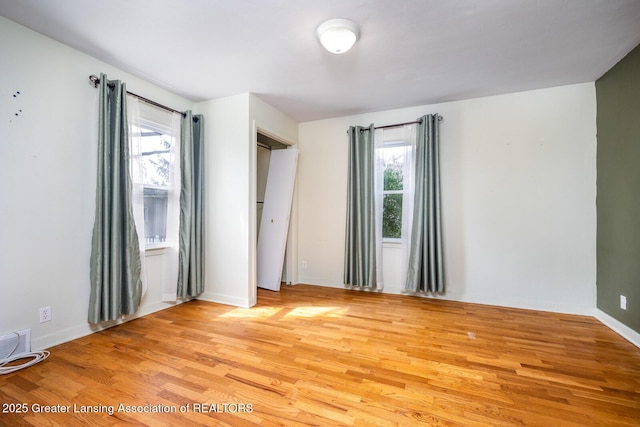 unfurnished room with visible vents, plenty of natural light, and light wood finished floors