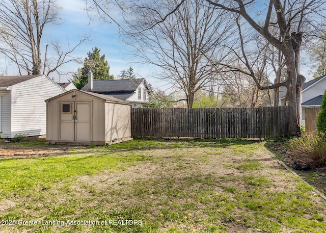 view of yard featuring fence, an outbuilding, and a storage unit
