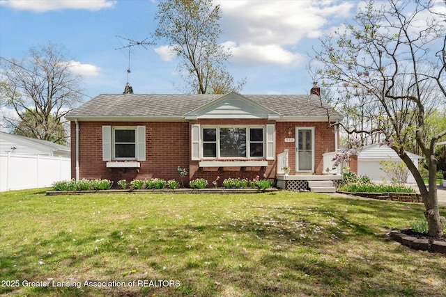 bungalow-style home with fence, a chimney, a front lawn, and brick siding