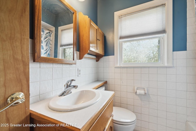bathroom with toilet, tile walls, curtained shower, and vanity