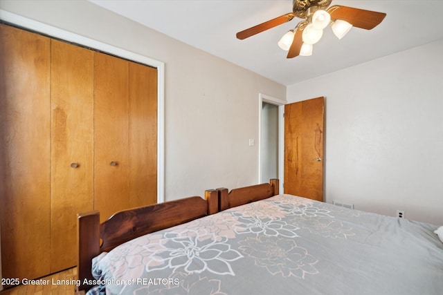 bedroom featuring ceiling fan, visible vents, and a closet