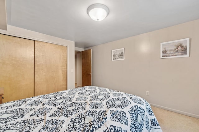 carpeted bedroom featuring a closet and baseboards