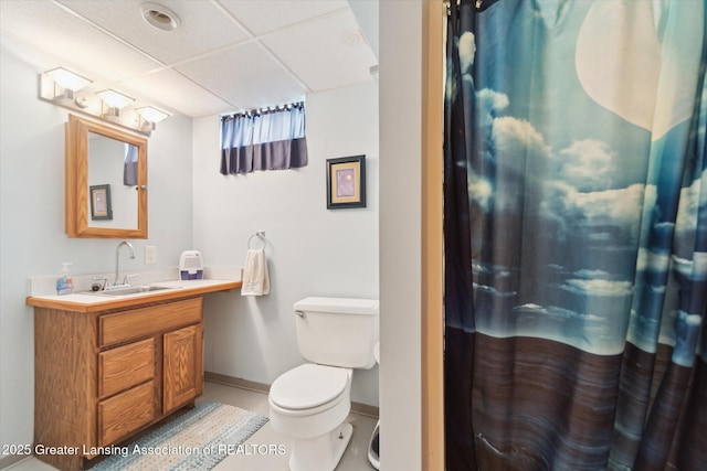 full bathroom featuring a paneled ceiling, vanity, baseboards, toilet, and a shower with shower curtain