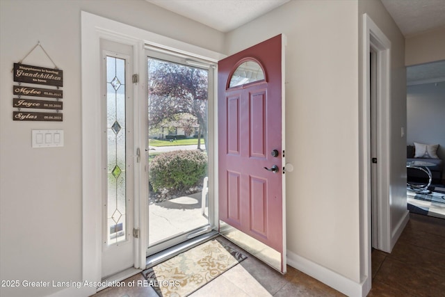 tiled foyer featuring baseboards