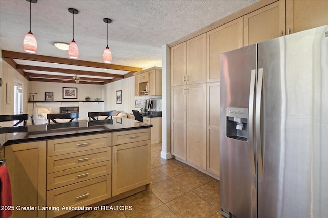 kitchen featuring a ceiling fan, a textured ceiling, dark countertops, tile patterned floors, and stainless steel fridge