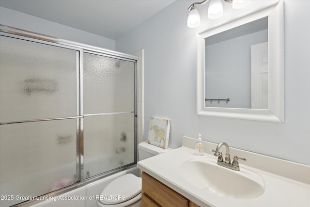 full bathroom featuring vanity, shower / bath combination with glass door, and toilet
