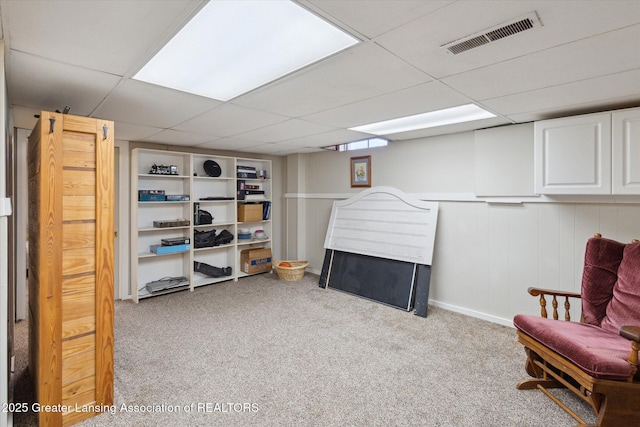 sitting room with visible vents, carpet flooring, and a paneled ceiling