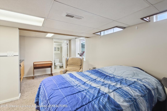 bedroom featuring light colored carpet, baseboards, visible vents, and a drop ceiling