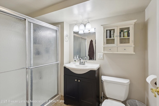 full bathroom featuring vanity, a stall shower, and toilet