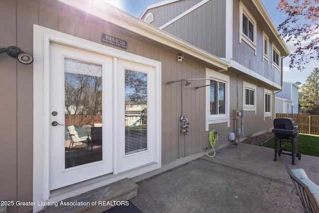 entrance to property with fence and a patio area