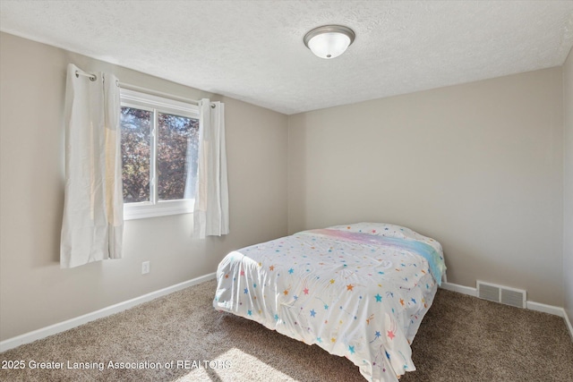 bedroom with carpet flooring, a textured ceiling, and visible vents