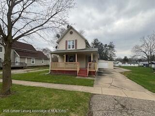 512 S Cedar St, Owosso, MI 48867 - view of front of property featuring covered porch, a front yard, and a detached garage