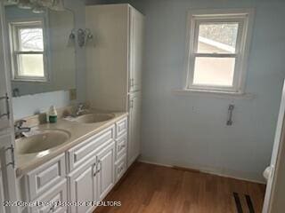 512 S Cedar St, Owosso, MI 48867 - full bathroom with plenty of natural light, a sink, wood finished floors, and double vanity