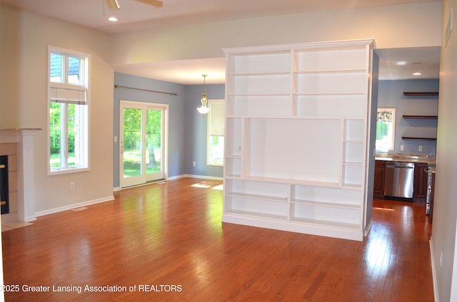 3401 N Burwick Dr, Port Huron, MI 48060 - unfurnished living room with wood finished floors, ceiling fan, a tile fireplace, baseboards, and recessed lighting