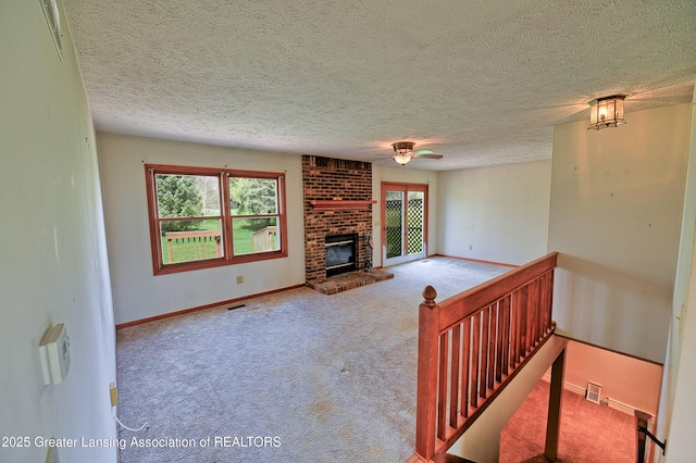 9408 W Scenic Lake Dr, Laingsburg, MI 48848 - unfurnished living room with carpet floors, a ceiling fan, a brick fireplace, and a wealth of natural light