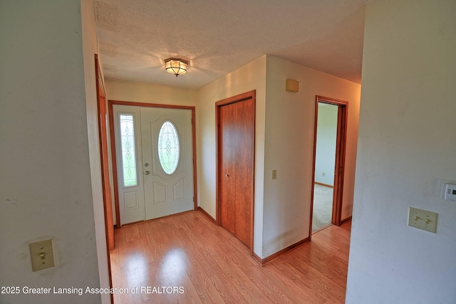 9408 W Scenic Lake Dr, Laingsburg, MI 48848 - entrance foyer featuring a textured ceiling, baseboards, and light wood-style floors