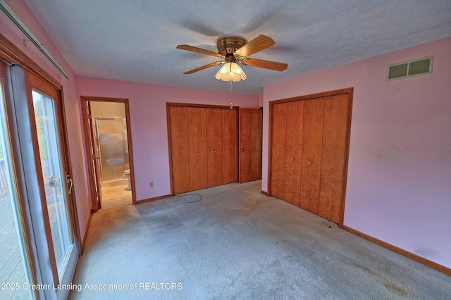 9408 W Scenic Lake Dr, Laingsburg, MI 48848 - unfurnished bedroom with visible vents, multiple closets, baseboards, light colored carpet, and ensuite bath