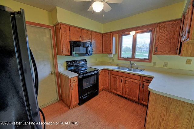 9408 W Scenic Lake Dr, Laingsburg, MI 48848 - kitchen with a ceiling fan, a sink, light countertops, black appliances, and light wood-style floors