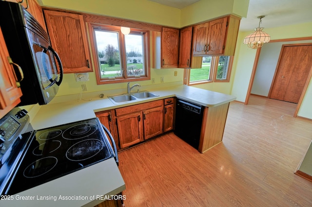 9408 W Scenic Lake Dr, Laingsburg, MI 48848 - kitchen featuring light wood-type flooring, a sink, a peninsula, and black appliances