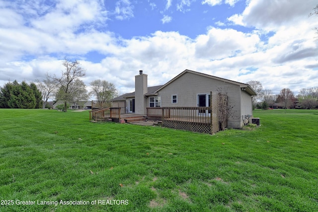 9408 W Scenic Lake Dr, Laingsburg, MI 48848 - back of house with central air condition unit, a deck, a chimney, and a lawn