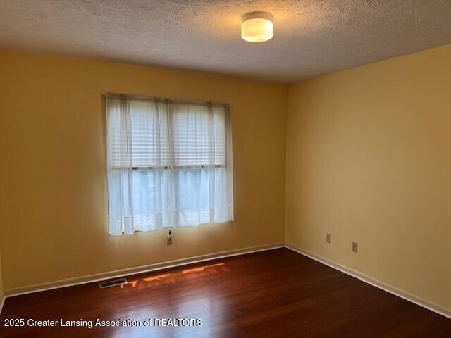 2434 Emerald Lake Dr, East Lansing, MI 48823 - empty room featuring a textured ceiling and wood finished floors