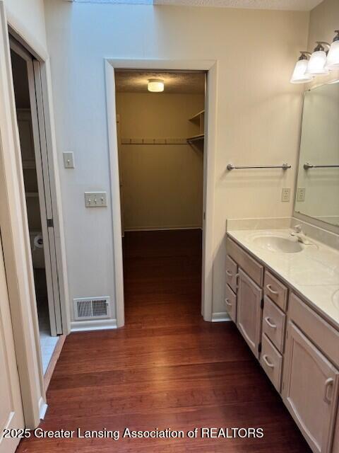 2434 Emerald Lake Dr, East Lansing, MI 48823 - full bath with wood finished floors, double vanity, and a walk in closet