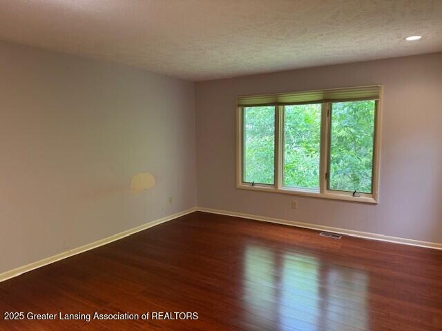 2434 Emerald Lake Dr, East Lansing, MI 48823 - empty room with wood finished floors, a textured ceiling, and recessed lighting