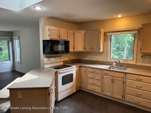 2434 Emerald Lake Dr, East Lansing, MI 48823 - kitchen with black microwave, white range with electric stovetop, light brown cabinetry, a peninsula, and recessed lighting