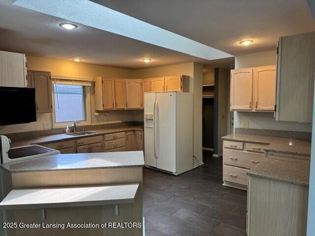 2434 Emerald Lake Dr, East Lansing, MI 48823 - kitchen with white refrigerator with ice dispenser, a peninsula, range, recessed lighting, and light brown cabinets