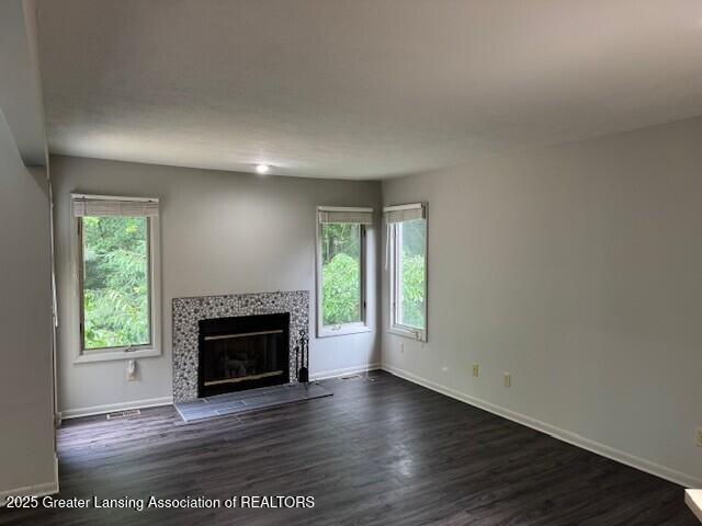 2434 Emerald Lake Dr, East Lansing, MI 48823 - unfurnished living room featuring healthy amount of natural light, dark wood-style floors, and a fireplace