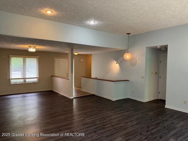 2434 Emerald Lake Dr, East Lansing, MI 48823 - spare room with a textured ceiling and dark wood-type flooring