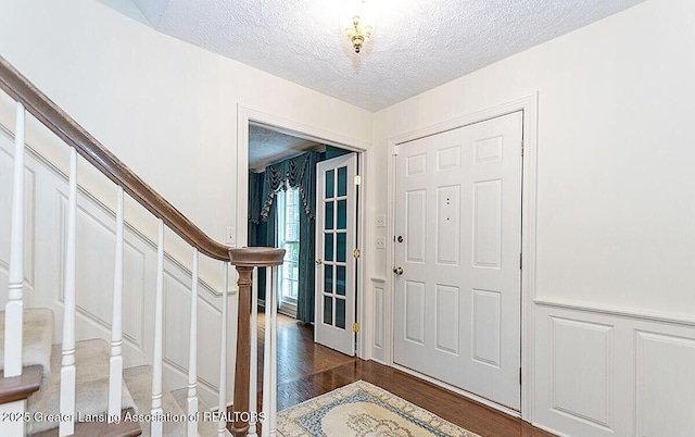 8505 W Willow Hwy, Grand Ledge, MI 48837 - foyer entrance with stairs, a textured ceiling, a decorative wall, dark wood finished floors, and wainscoting