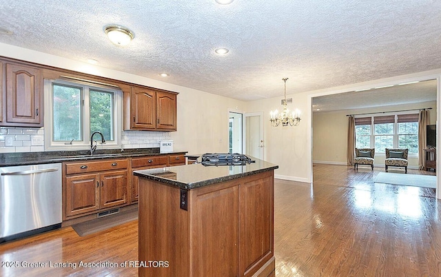 8505 W Willow Hwy, Grand Ledge, MI 48837 - kitchen with stainless steel appliances, a center island, a textured ceiling, a chandelier, and a sink