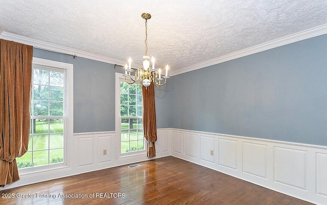 8505 W Willow Hwy, Grand Ledge, MI 48837 - unfurnished room with a chandelier, dark wood-type flooring, a textured ceiling, wainscoting, and ornamental molding
